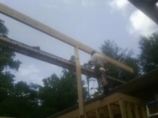 Carpenter setting a ridge beam over a new addition frame — Ice Dam Removal by Roofing Brothers in Robstown